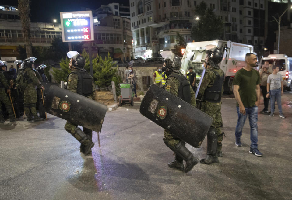 Angry demonstrators set fires, block the streets of the city center and clash with riot police following the death of Nizar Banat, an outspoken critic of the Palestinian Authority, in the West Bank city of Ramallah, Thursday, June 24, 2021. Banat who was a candidate in parliamentary elections called off earlier this year died after Palestinian security forces arrested him and beat him with batons on Thursday, his family said. (AP Photo/Nasser Nasser)