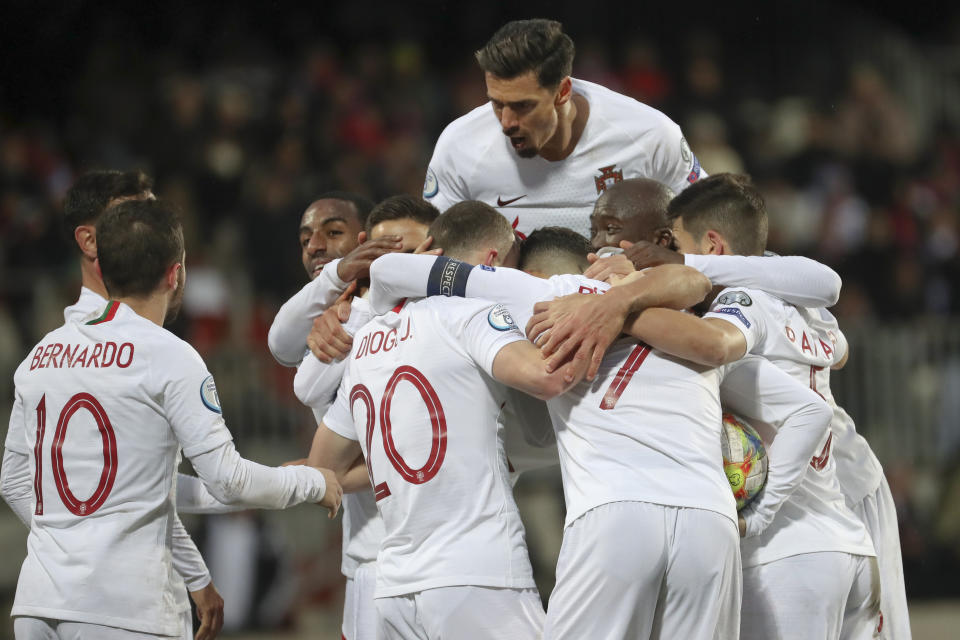 Portugal players celebrate after their teammate Cristiano Ronaldo scored their side's second goal during the Euro 2020 group B qualifying soccer match between Luxembourg and Portugal at the Josy Barthel stadium in Luxembourg, Sunday, Nov. 17, 2019. (AP Photo/Francisco Seco)