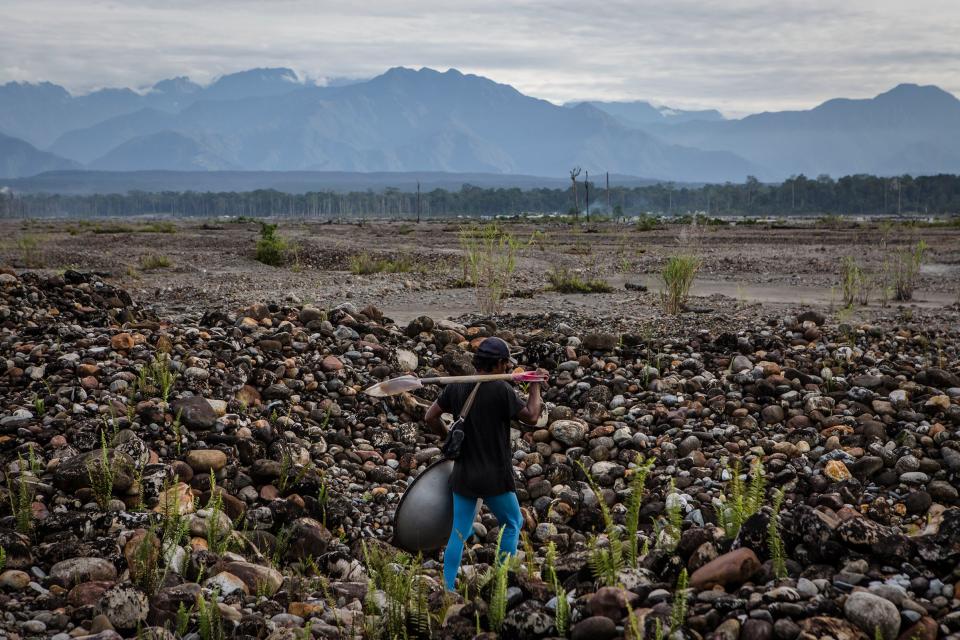 A illegal gold miner walks as they pan for gold along the Aikwa river are located within Freeport's official mining operations in Timika, Papua Province, Indonesia, on Feb. 4, 2017.