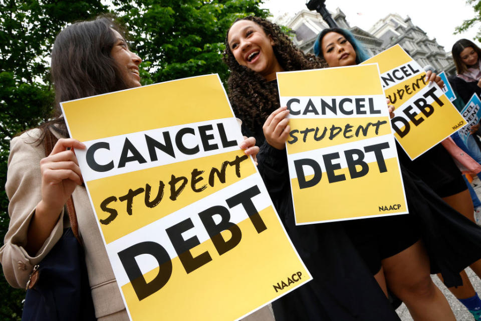 Protesters holding up "Cancel student debt" signs