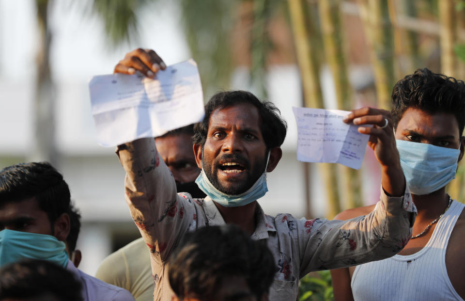 A laborer displays his identification as he protests against poor treatment at the quarantine center he has been kept in, along with others who arrived from outside the state, in Prayagraj, India, Wednesday, April 29, 2020, amid shelter-in-place orders. (AP Photo/Rajesh Kumar Singh)