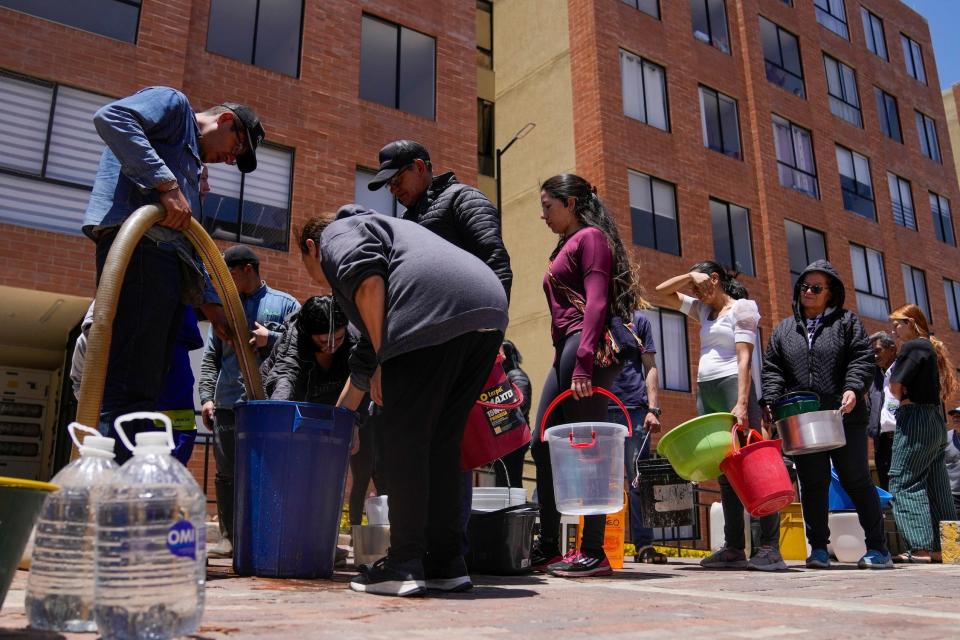 Residents line up to collect water from a truck during water rationing in La Calera, on the outskirts of Bogota, Colombia