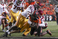 Oregon State running back Deshaun Fenwick scores a touchdown as Southern California linebacker Eric Gentry (18) and defensive back Anthony Beavers Jr. (15) try to bring him down during the first half of an NCAA college football game Saturday, Sept. 24, 2022, in Corvallis, Ore. (AP Photo/Amanda Loman)