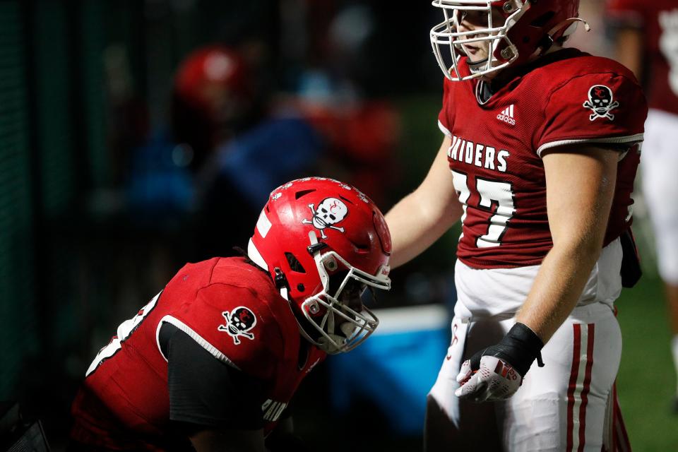 A teammate checks on Akeem Lane as he sits along on the bench during Friday's game against Sandy Creek at Pooler Stadium.