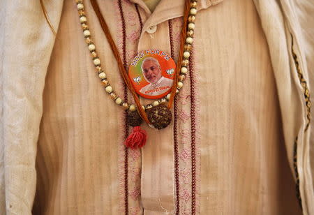 A Sadhu or Hindu holyman wears a badge with an image of Hindu nationalist Narendra Modi, then-prime ministerial candidate for India's main opposition Bharatiya Janata Party (BJP), outside an ashram in Ayodhya in the northern Indian state of Uttar Pradesh in this May 6, 2014 file photo. REUTERS/Anindito Mukherjee/Files