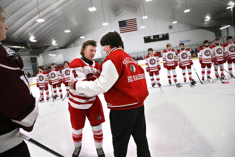 Spaulding High School athlete Matt Gould, right, greets his good friend and hockey player Owen Nesbitt at center ice prior to the start of Wednesday's Division II boys hockey game against Portsmouth/Newmarket at Rochester Ice Arena.