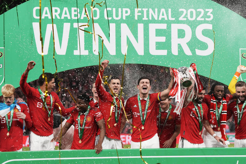 Manchester United's team players celebrate with the trophy as they won the English League Cup final soccer match between Manchester United and Newcastle United at Wembley Stadium in London, Sunday, Feb. 26, 2023. (AP Photo/Alastair Grant)