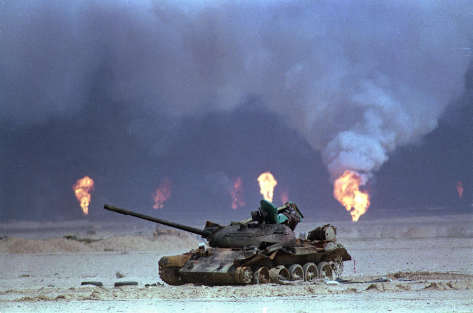 Image: A destroyed Iraqi tank rests near a series of oil well fires (David Longstreath / AP file)