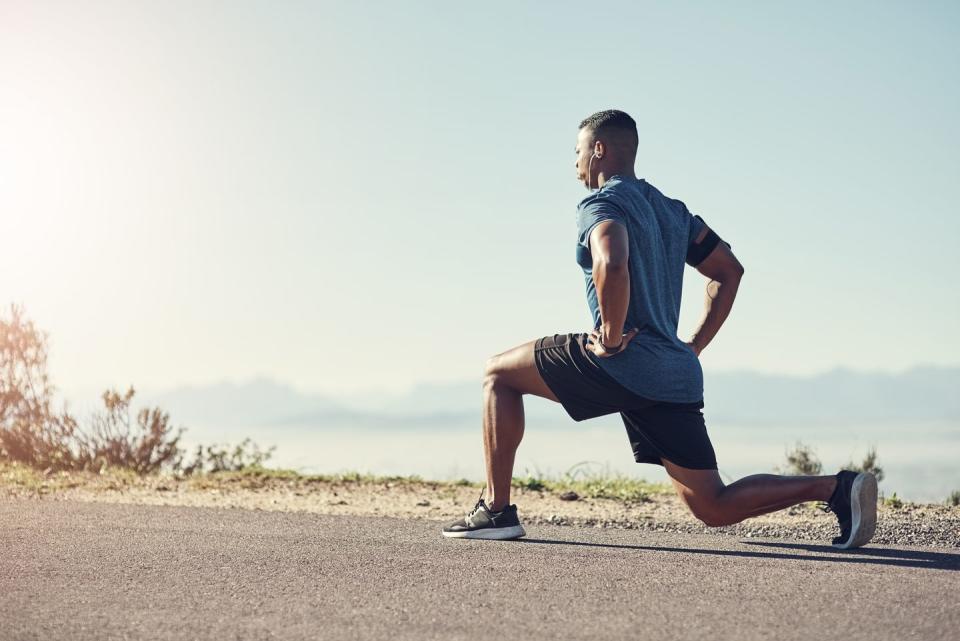 shot of a young handsome man doing lunges outdoors