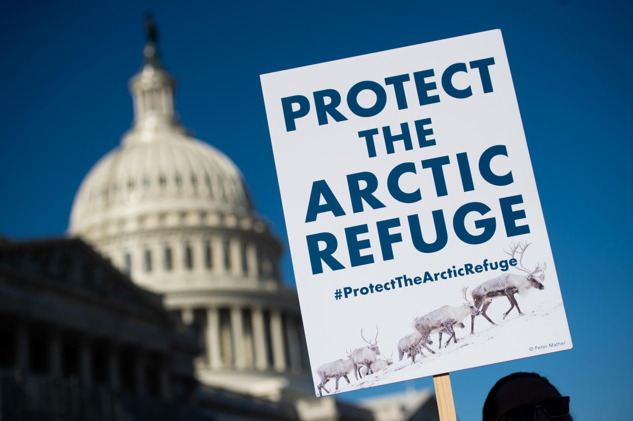 A demonstrator holds a sign against drilling in the Arctic Refuge
