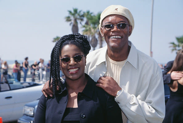 LaTanya and Samuel stand together outside, smiling, with his hands on her shoulders