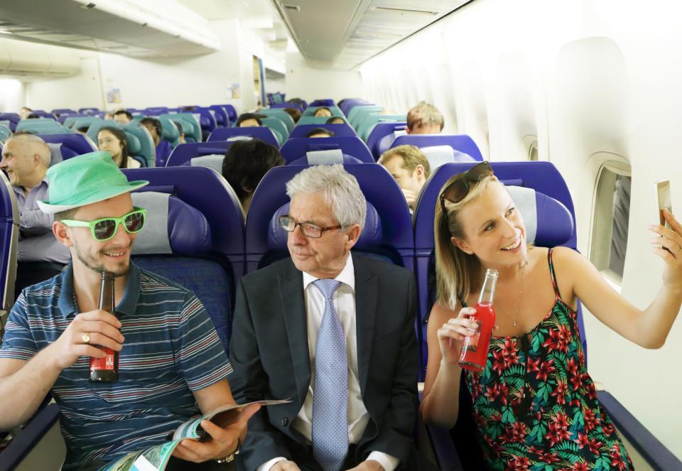 Annoyed man on airplane between young adults