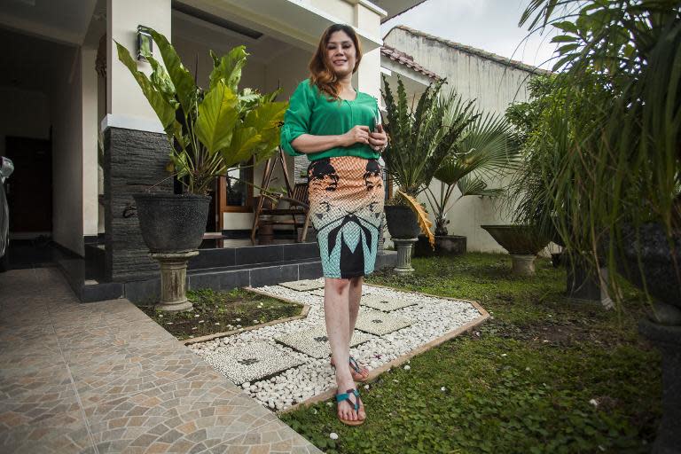 Wina Lia, una viuda de 40 años y dueña de un salón de belleza en Sleman, Indonesia, posa junto a su casa, puesta a la venta junto con su mano, el 11 de marzo de 2015