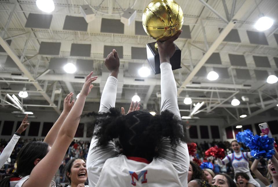 Monterey's Kelly Mora lifts the trophy up after the team's win against Amarillo High in the Region I-5A girls basketball quarterfinal game, Tuesday, Feb. 21, 2023, at Wildcat Gymnasium in Littlefield.