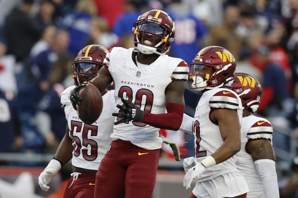 Washington Commanders safety Jartavius Martin (20) celebrates with defensive end KJ Henry (55) and safety Terrell Burgess, second from right, after intercepting a pass intended for New England Patriots wide receiver JuJu Smith-Schuster (not shown) in the second half of an NFL football game, Sunday, Nov. 5, 2023, in Foxborough, Mass. (AP Photo/Michael Dwyer)