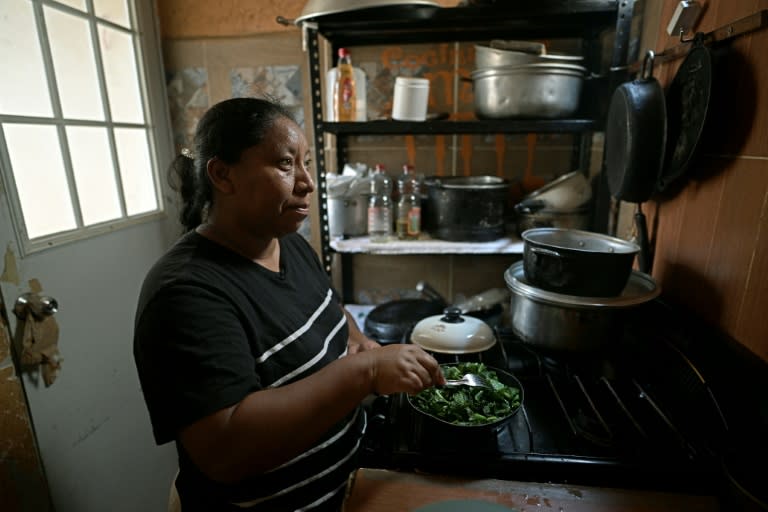 Rosalina Gómez, empleada de limpieza en el aeropuerto de Cancún, cocina en su casa, en abril de 2024 (CARL DE SOUZA)