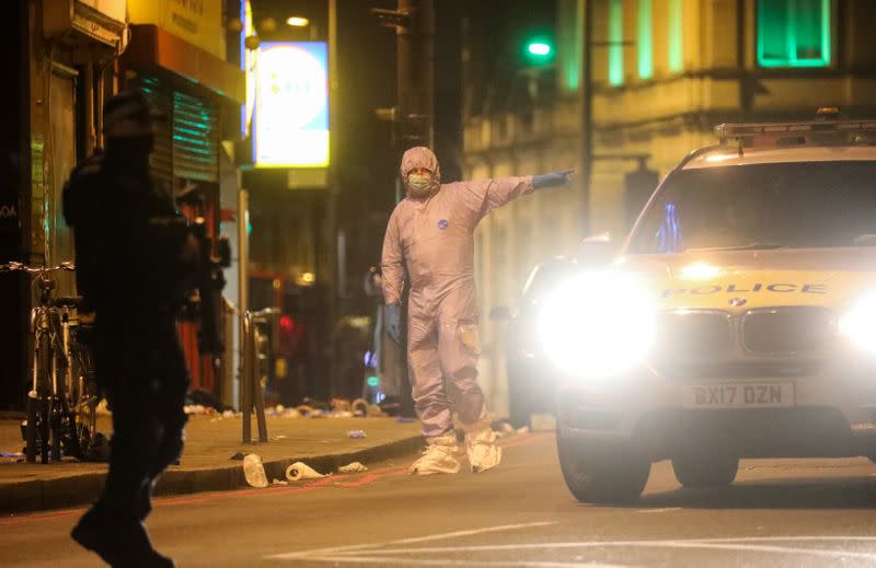 A police forensics officer gestures near the site where a man was shot by armed officers in Streatham, south London