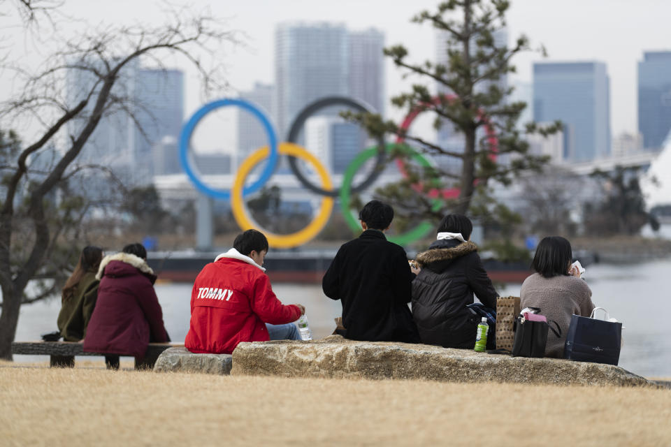 People have lunch at the Odaiba Marine Park where a statue of the Olympic rings is displayed in Tokyo on Friday, Feb. 12, 2021. (AP Photo/Hiro Komae)