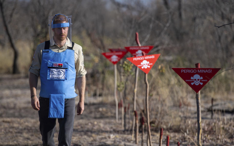 Britain's Prince Harry walks through a minefield in Dirico, Angola Friday Sept. 27, 2019, during a visit to see the work of landmine clearance charity the Halo Trust, on day five of the royal tour of Africa. Prince Harry is following in the footsteps of his late mother, Princess Diana, whose walk through an active mine field in Angola years ago helped to lead to a global ban on the deadly weapons. (Dominic Lipinski/Pool via AP)