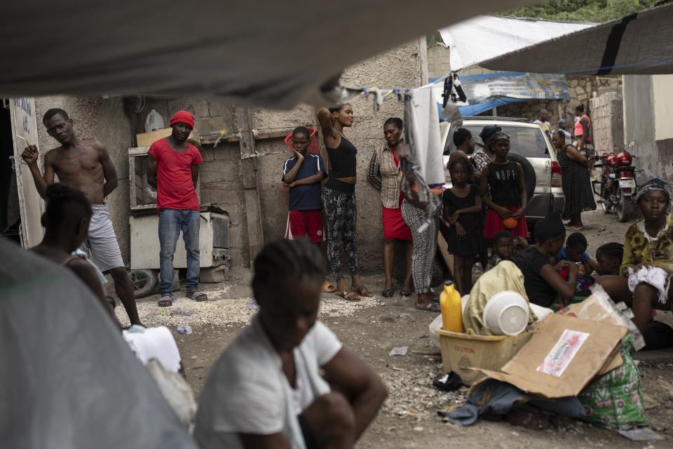 People displaced by gang violence gather in the front yard of Jean-Kere Almicar's front yard, where they have sought refuge, in Port-au-Prince, Haiti, Friday, June 2, 2023. Nearly 200 people who once lived in the Cite Soleil slum near Almicar’s house are now camped out in his front yard and nearby areas. They are among the nearly 165,000 Haitians who have fled their homes amid a surge in gang violence. (AP Photo/Ariana Cubillos)