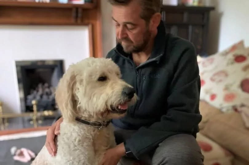 Mr Caulfield pictured at home with his dog, Wesley