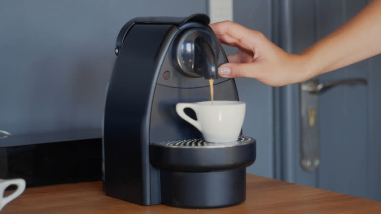 Someone making coffee with pod machine