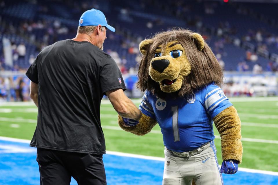 Lions coach Dan Campbell shakes hands with mascot Roary before a preseason game against the Giants at Ford Field on Friday, Aug. 11, 2023.