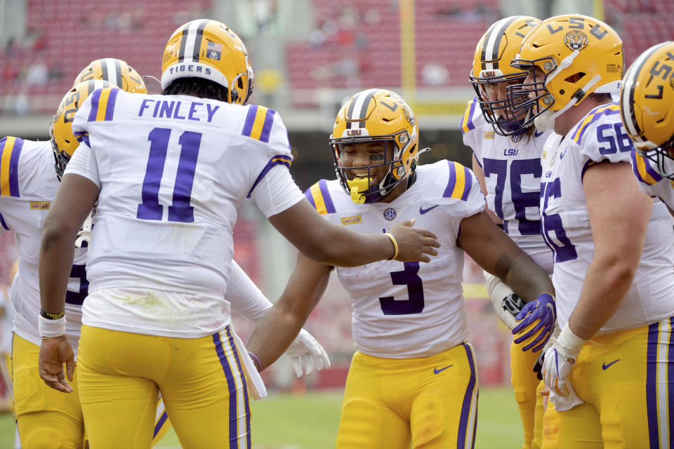 LSU running back Tyrion Davis-Price (3) celebrates with teammates after scoring a touchdown against Arkansas during the first half of an NCAA college football game Saturday, Nov. 21, 2020, in Fayetteville, Ark. (AP Photo/Michael Woods)