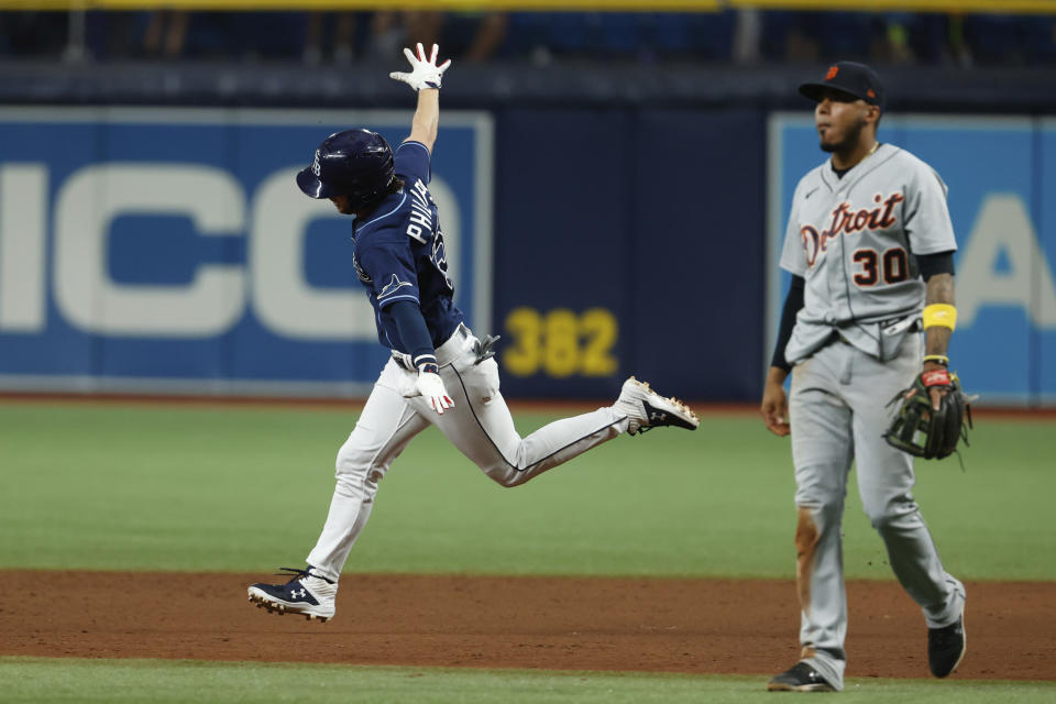 Tampa Bay Rays' Brett Phillips, left, circles the bases after hitting a three-run home run as Detroit Tigers second baseman Harold Castro (30) walks off the filed during the 10th inning of a baseball game Friday, Sept. 17, 2021, in St. Petersburg, Fla. (AP Photo/Scott Audette)