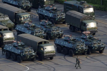 Military vehicles are parked on the grounds of the Shenzhen Bay Sports Center in Shenzhen