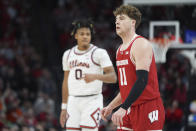 Wisconsin guard Max Klesmit (11) stands on the court as Illinois guard Terrence Shannon Jr. (0) gestures after making a 3-point shot during the second half of an NCAA college basketball game in the championship of the Big Ten Conference tournament, Sunday, March 17, 2024, in Minneapolis. (AP Photo/Abbie Parr)