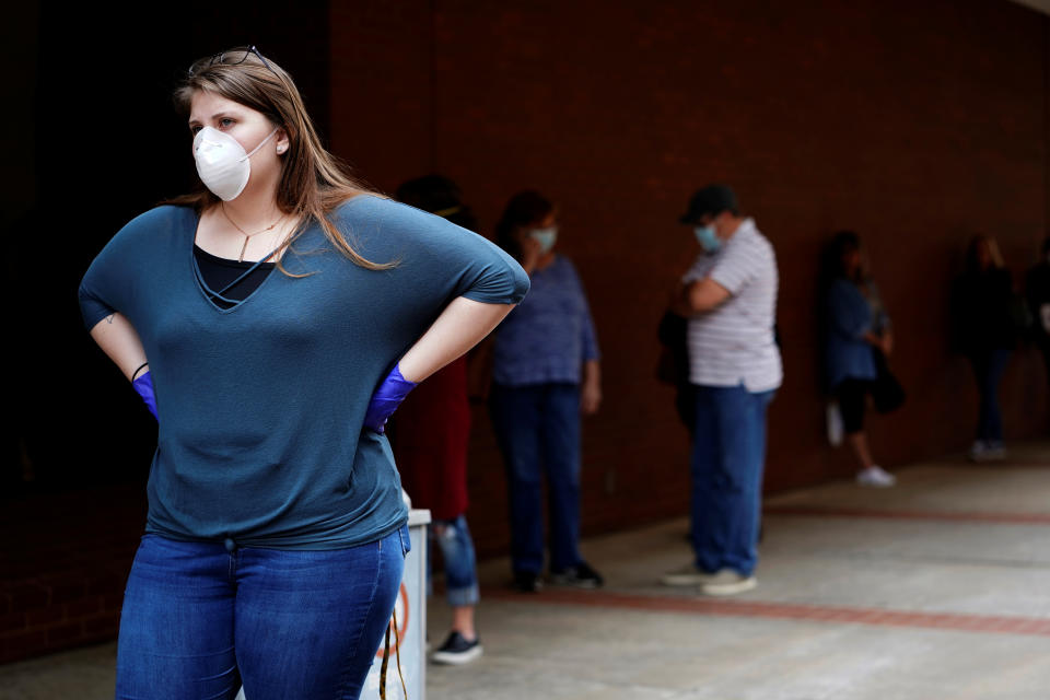 A woman who lost her job waits in line to file for unemployment following an outbreak of COVID, at an Arkansas Workforce Center in Fort Smith, Arkansas, April 6, 2020. REUTERS/Nick Oxford