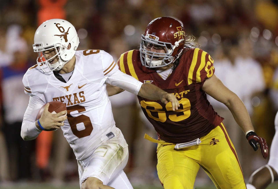 FILE - In this Oct. 3, 2013, file photo, Texas quarterback Case McCoy runs from Iowa State's Nick Kron during the second half of an NCAA college football game in Ames, Iowa. Kron was arrested in connection with an assault of a University of Iowa basketball star in May. Kron, 29, of Nashville, Tenn., faces an assault causing bodily injury charge for allegedly attacking Jordan Bohannon, a Hawkeye guard, outside a downtown Iowa City, Iowa, bar. (AP Photo/Charlie Neibergall, File)