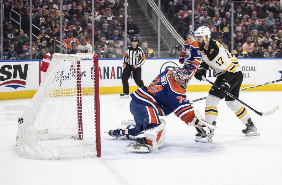Boston Bruins' Nick Foligno (17) scores against Edmonton Oilers' goalie Stuart Skinner (74) during first-period NHL hockey game action in Edmonton, Alberta, Monday, Feb. 27, 2023. (Jason Franson/The Canadian Press via AP)