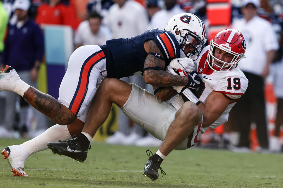 FILE - Georgia tight end Brock Bowers (19) catches a pass as Auburn safety Donovan Kaufman defends during the second half of an NCAA football game, Saturday, Sept. 30, 2023, in Auburn, Ala. As he showed in three seasons at Georgia, Bowers is a dynamic receiver with the ability to create separation, make contested catches and create big plays after the catch, along with being a more than capable blocker.(AP Photo/ Butch Dill, File)