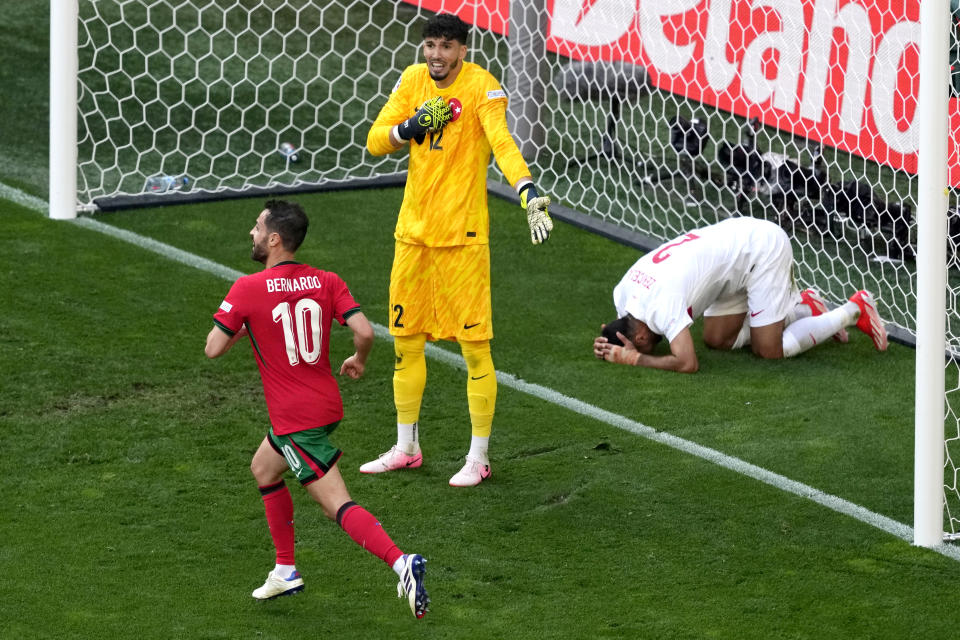 Turkey's goalkeeper Altay Bayindir and Zeki Celik, right, react after and own goal by teammate Samet Akaydin during a Group F match between Turkey and Portugal at the Euro 2024 soccer tournament in Dortmund, Germany, Saturday, June 22, 2024. (AP Photo/Michael Probst)