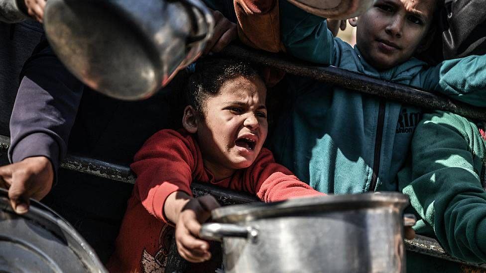 Shaima con una olla entre la multitud