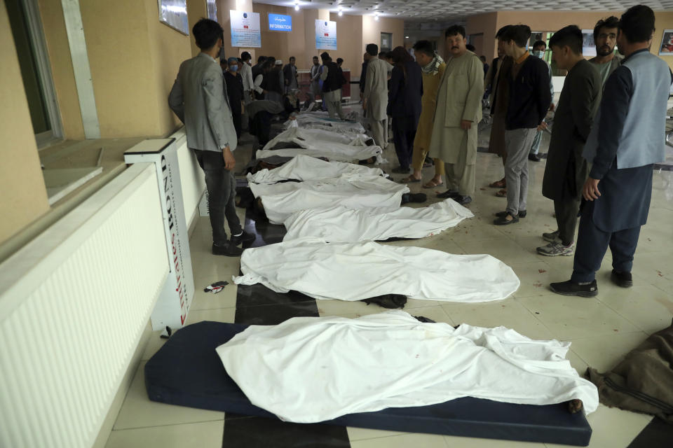 Afghan men try to identify the dead bodies at a hospital after a bomb explosion near a school west of Kabul, Afghanistan, Saturday, May 8, 2021. A bomb exploded near a school in west Kabul on Saturday, killing several people, many them young students, an Afghan government spokesmen said. (AP Photo/Rahmat Gul)