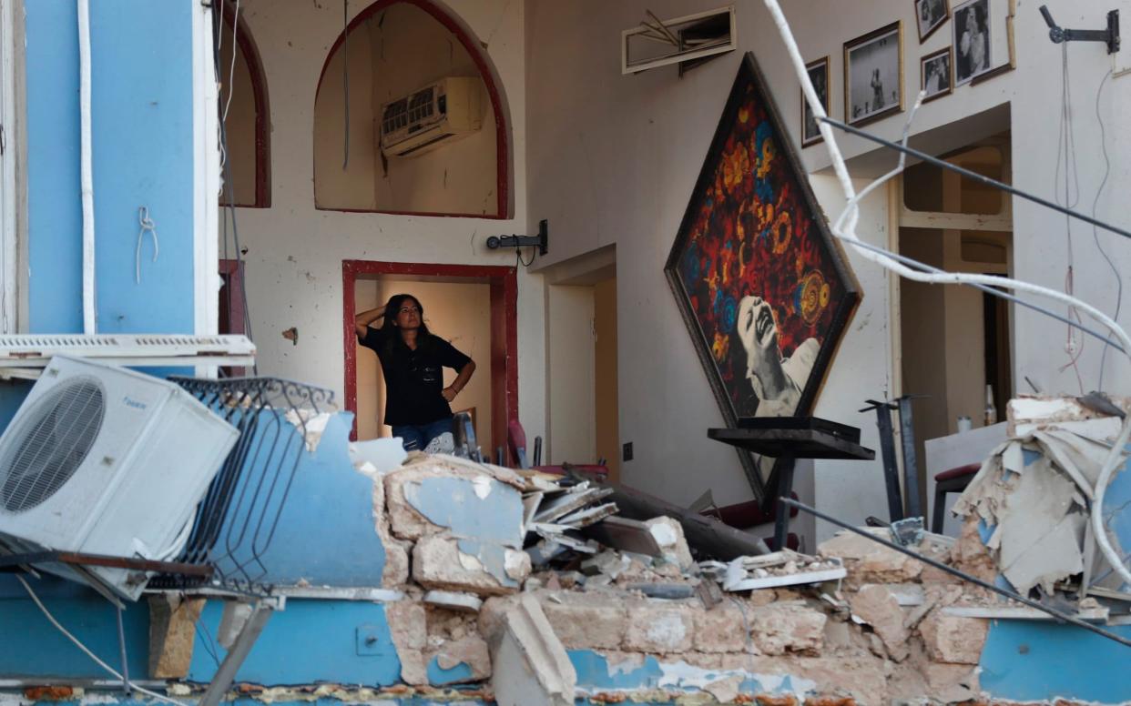 A woman stands inside a damaged restaurant a day after an explosion hit the seaport of Beirut - AP Photo/Hussein Malla