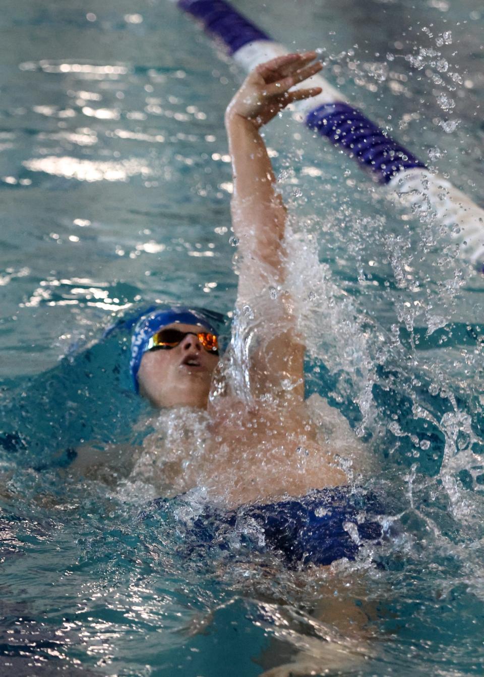 Dundee's Drew Bylow swims to a win in the 100-yard backstroke during the Monroe County Championship Saturday, February 4, 2023 at Dundee High School.