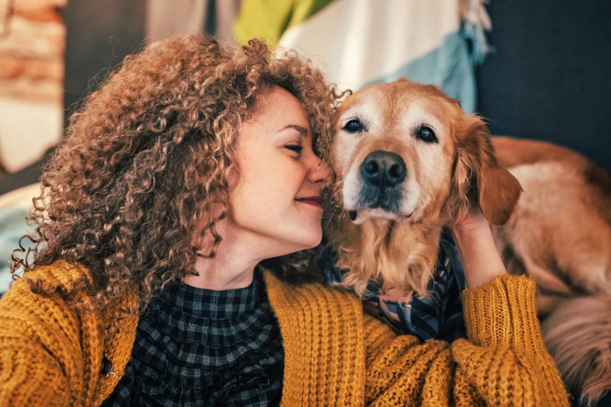 woman snuggling her senior golden retriever; how to make your dog's golden years more golden