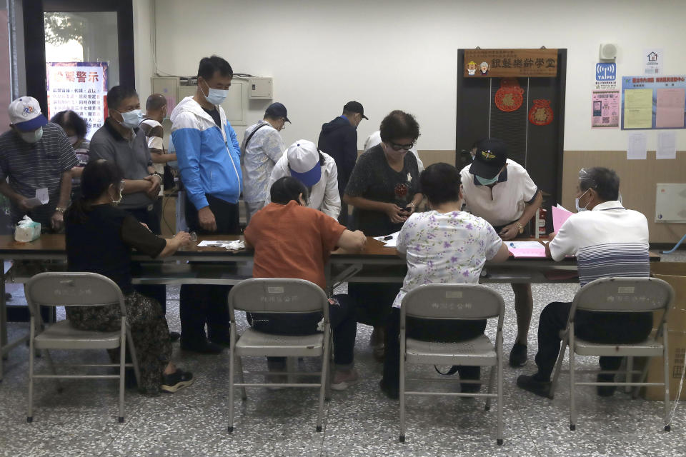 Members of the Nationalist Party, or KMT, prepare to cast their ballot for election of its party chairman at a polling station in Taipei, Taiwan, Saturday, Sept. 25, 2021. Fraught relations with neighboring China are dominating Saturday's election for the leader of Taiwan’s main opposition Nationalist Party. (AP Photo/Chiang Ying-ying)