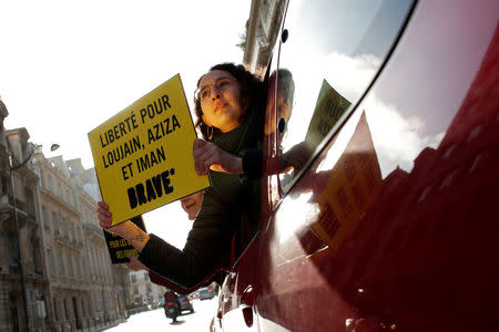 Demonstrators from Amnesty International hold placards outside the Saudi Arabian Embassy on International Women's day to urge Saudi authorities to release jailed women's rights activists Loujain al-Hathloul, Eman al-Nafjan and Aziza al-Yousef in Paris, France, March 8, 2019. The placard reads: "Freedom for Loujain, Aziza and Iman". REUTERS/Benoit Tessier