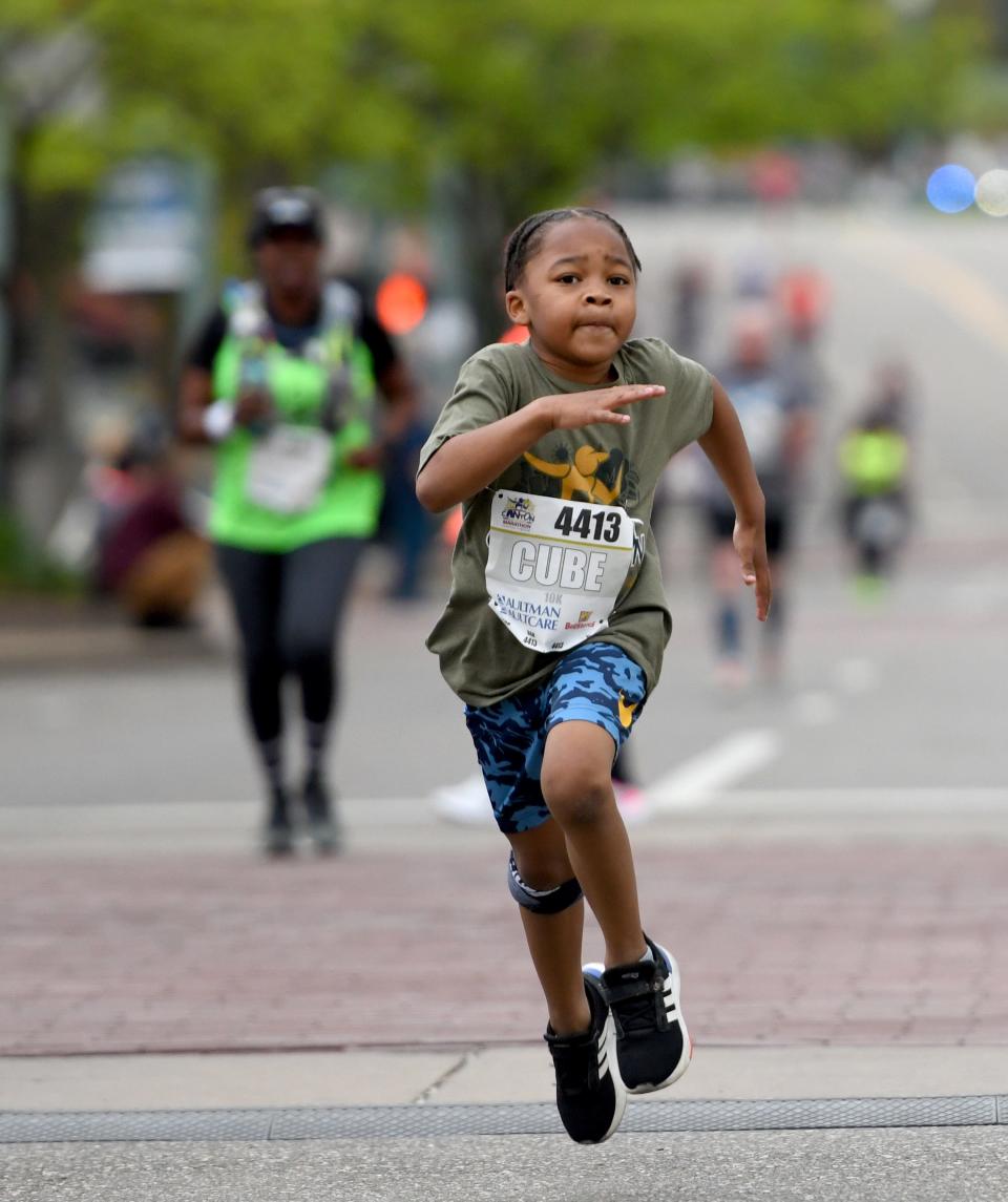 Timothy Williamson, 8, Cleveland, runs to the finish of Sunday events of the 10th Canton Hall of Fame Marathon race weekend.