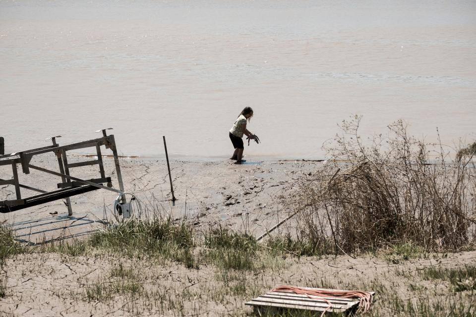 A woman releases fish which were stranded in her backyard into the still flooded Lake Sanford following extreme flooding throughout central Michigan on May 20, 2020 in Sanford, Michigan.