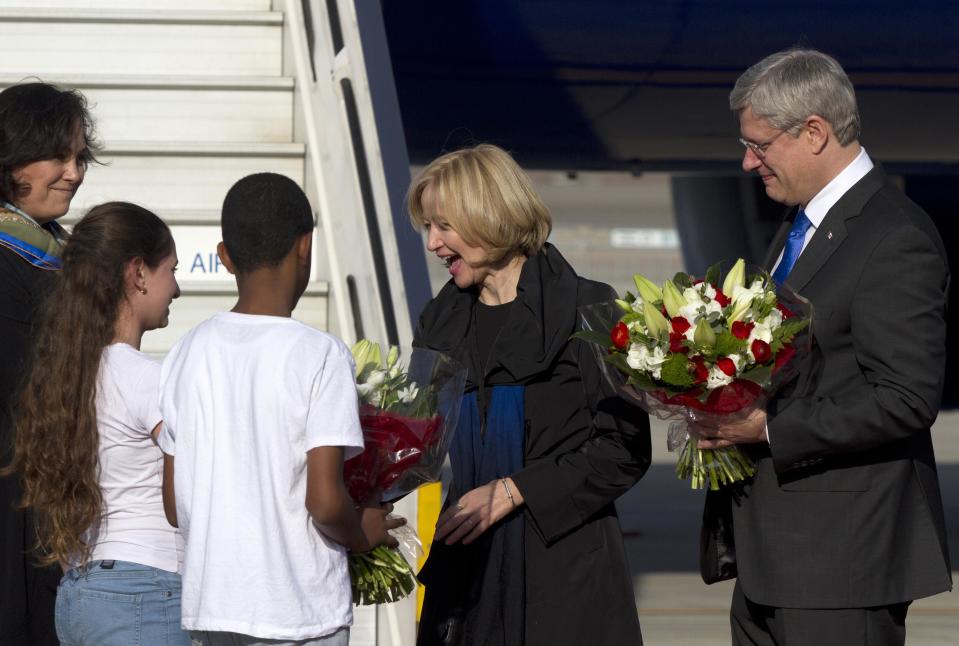 Canada's Prime Minister Harper and his wife receive flowers after landing at Ben Gurion International Airport