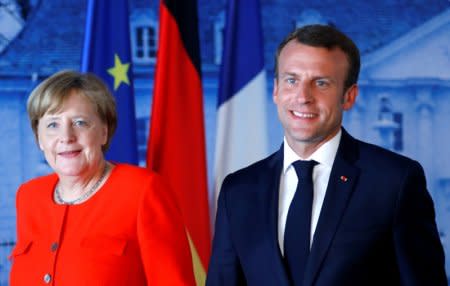 FILE PHOTO: German Chancellor Angela Merkel and French President Emmanuel Macron leave after a press conference after their meeting at the German government guesthouse Meseberg Palace in Meseberg, Germany, June 19, 2018. REUTERS/Hannibal Hanschke/File Photo