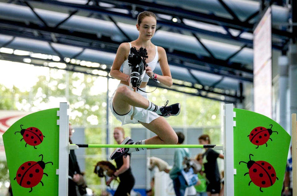 A participant clears the bar during the first German Hobby Horsing Championship in Frankfurt, Germany, Saturday, Sept. 14, 2024. (AP Photo/Michael Probst)