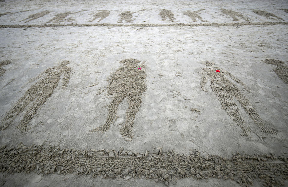 A view of drawings of soldiers on Sunny Sands beach , during the Pages of the Sea commemorative event on the 100th anniversary of the signing of the Armistice which marked the end of the First World War, in Folkestone, England, Sunday, Nov. 11, 2018. Portraits of soldiers who perished during World War I have been drawn on a number of British beaches only to be washed into the sea by rising tidewater. The homage Sunday to fallen service men and women was carried out on beaches in Blackpool, Cornwall, the Shetland islands and other parts of the country as part of the nationwide Armistice Day proceedings inspired by filmmaker Danny Boyle as an informal gesture of remembrance. (Steve Parsons/PA via AP)