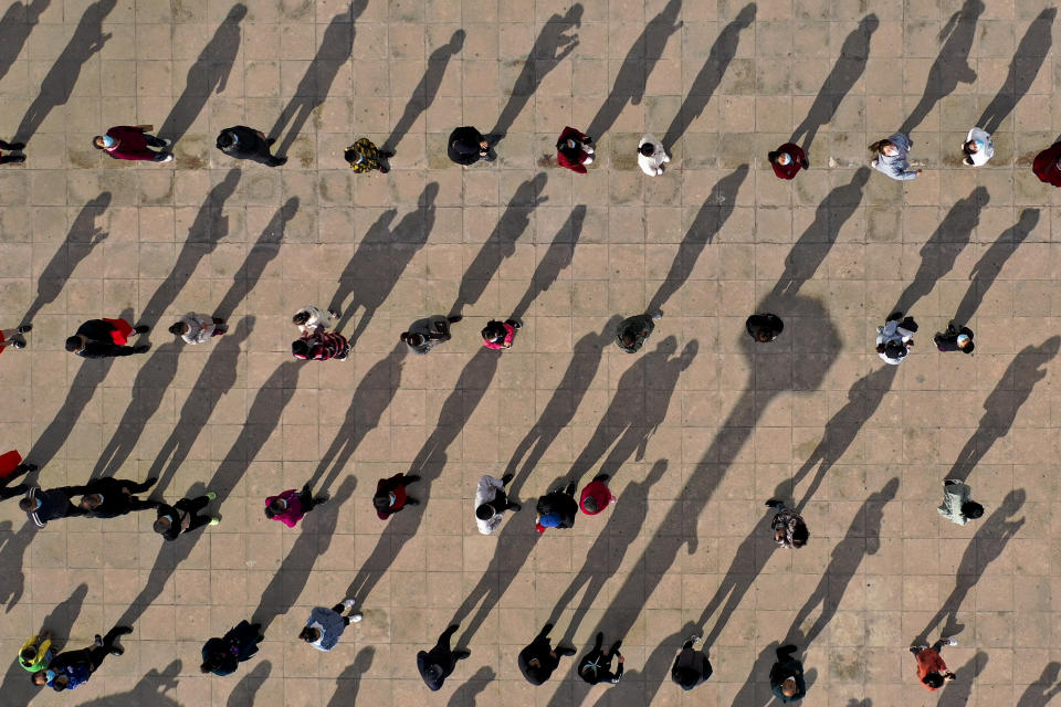 This photo released by Xinhua News Agency shows an aerial view of residents lining up to receive a swab for the coronavirus test during a mass testing in Xingqing District of Yinchuan in northwest China's Ningxia Hui Autonomous Region Saturday, Oct. 23, 2021. China's Gansu has closed all tourist sites following the reporting of new COVID-19 cases in the northwestern province. Gansu lies along the ancient Silk Road and is famed for the Dunhuang grottoes filled with Buddhist images and other ancient religious sites. (Wang Peng/Xinhua via AP)